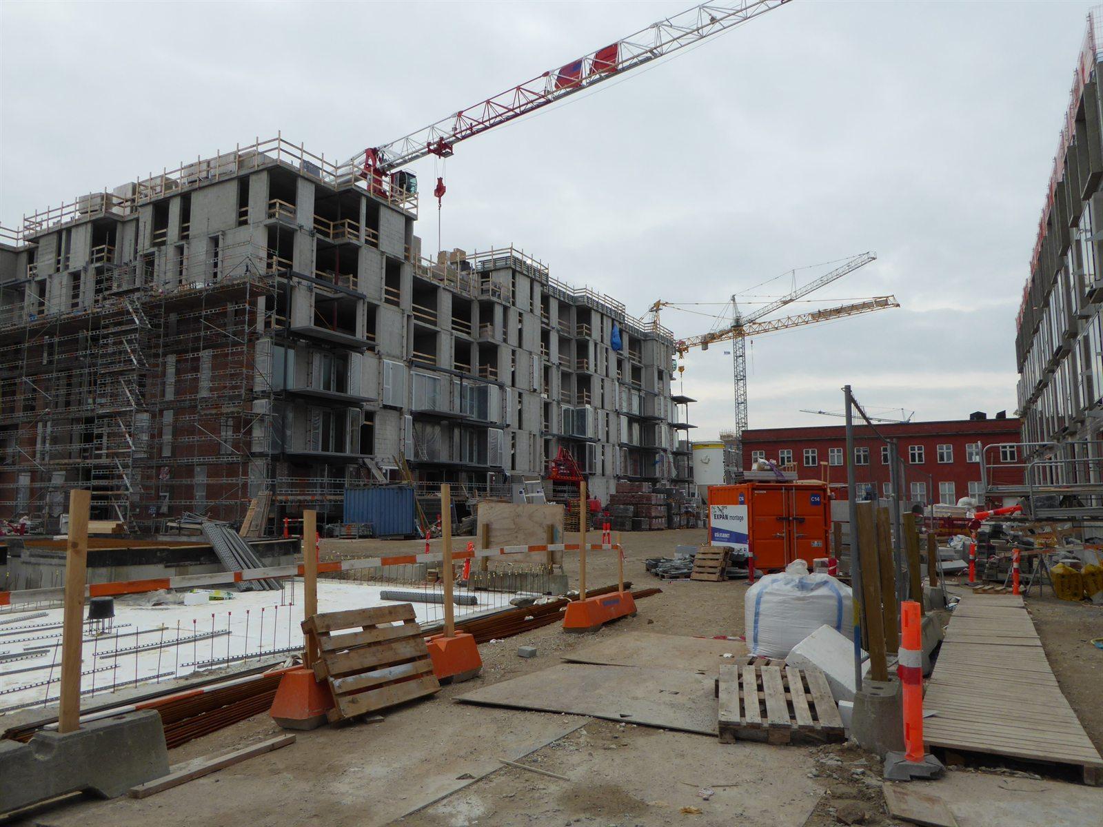 Building site at street level in Nordhavn, Copenhagen, with site fencing and materials